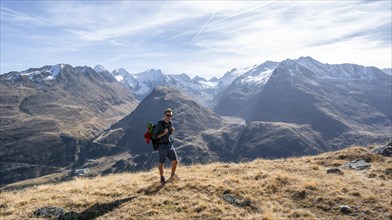 Mountaineers on a hiking trail, Gurgler Seenplatte, glaciated mountain peaks behind, in autumn,
