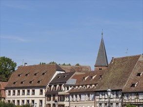 Traditional old town with half-timbered houses and a church tower under a blue sky, historic house