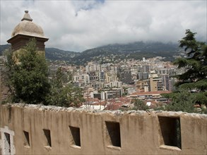 View over a city from an old city wall, surrounded by mountains and clouds, Monte Carlo, Monaco,