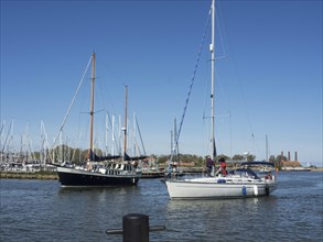 Several sailing boats in the harbour, clear blue water and a sunny sky, Enkhuizen, Nirderlande