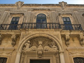 Historic building with ornate balcony and magnificent stucco ornaments, the town of mdina on the