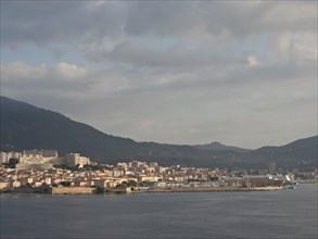 City on the coast, surrounded by mountains, under a cloudy evening sky, Corsica, ajaccio, France,