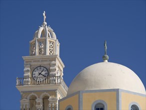 A yellow and white church with a bell tower and a clock under a clear blue sky, The volcanic island
