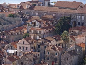 Bird's eye view of densely built historic buildings with red tiled roofs in a mediterranean city,