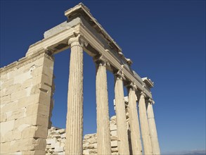 Ancient temple columns against a deep blue sky, Ancient buildings with columns and trees on the