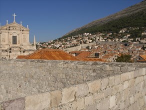 View of a city with historic architecture, including a church, and a mountain in the background,
