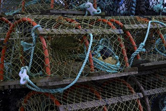 Stacks of lobster traps with fishing nets and ropes, maritime atmosphere