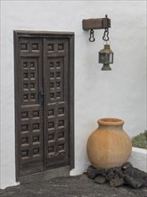 Rustic wooden door with lantern and large pot outside, Lanzarote, Spain, Europe
