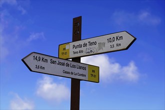 A signpost with distances in front of a blue, cloudy sky, Tenerife, Canary Islands, Spain, Europe