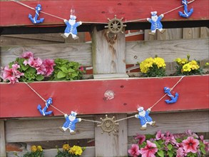 Wooden fence with floral decorations and decorative bear figures, Baltrum Germany