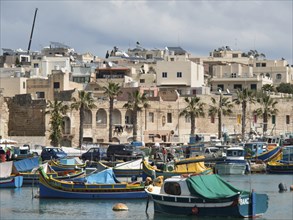 Panorama of the harbour with colourful fishing boats in the water and Mediterranean buildings in