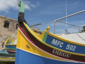 Close-up of a colourfully painted fishing boat with the inscription MFC 502 Diegu in front of a