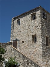 A three-storey stone house with small windows under a clear blue sky, Provence, le Castellet,