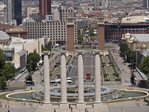 View of several imposing columns and a fountain surrounded by urban architecture, Barcelona, Spain,
