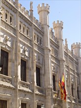 Magnificent historic building facade with richly decorated windows and flags, palma de Majorca with