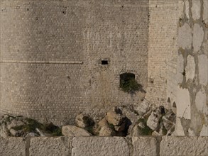 Close-up of a medieval stone wall and fortress with neighbouring rocks, the old town of Dubrovnik