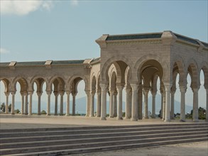 An exterior stone structure with arches and columns under a sunny sky, Tunis in Africa with Roman