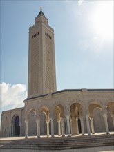 High mosque with minaret and arches, in sunlight, clear line against clear sky, Tunis in Africa