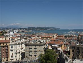 Panoramic view of a coastal town with rooftops, harbour and boats under a blue sky, Bari, Italy,