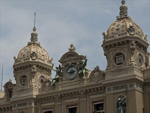 Facade of an elegant historic building with clock, decorative sculptures and towers, Monte Carlo,