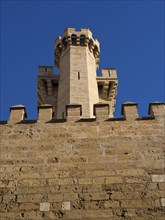 Medieval castle tower with battlements in front of a clear blue sky, palma de Majorca with its