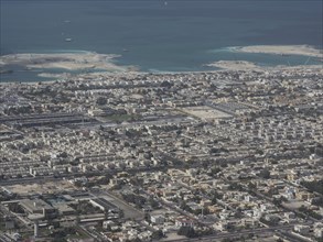 Aerial view of a coastal city with water and islands in the background by day, Dubai, Arab Emirates