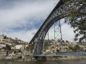 Steel bridge spans a city with historic buildings, The old town of Porto on the Douro River with