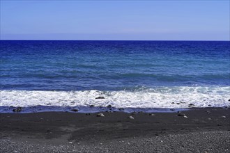 Tenerife, Canary Islands, Spain, Europe, View of a calm beach with waves gently hitting the black