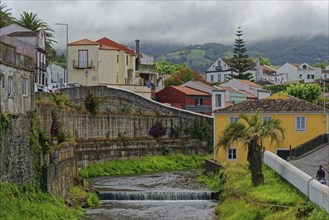 An idyllic village with colourfully painted houses, through which the Ribeira Grande river flows,