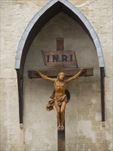 Wooden cross with Jesus sculpture and INRI sign on a church wall, Marseille on the Mediterranean
