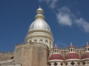 Large dome and several smaller towers of a religious building under a clear blue sky, the island of