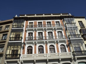 Facade of a historic building with balconies and many windows on a sunny day, toledo, spain