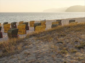 Beach chairs on the beach near dunes and sea, quiet atmosphere at sunset, autumn atmosphere on the
