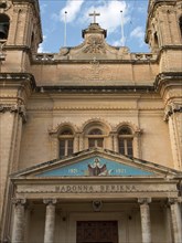 Close-up of a historic church facade with religious symbols and inscriptions, Valetta, Malta,