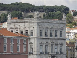 Historic building in an urban landscape surrounded by green hills and other houses, Lisbon,