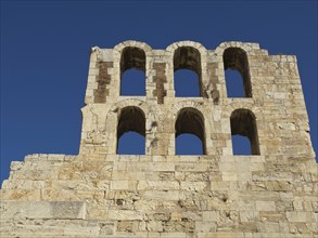 Ancient wall with arches and striking masonry against a blue sky, Ancient buildings with columns