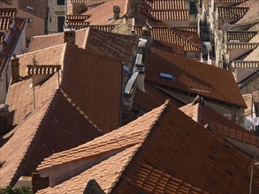 Close-up of tiled roofs in an old town showing narrow streets and densely built-up houses, the old