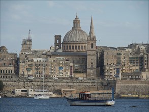 Historic city with impressive cathedral and boat in the foreground, Valetta, Malta, Europe