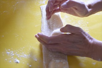 Preparation of fresh homemade pasta mezzaluna with ricotta, dough is folded together