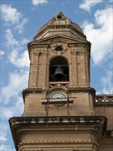High church tower with large bell and clock in front of a blue sky, Valetta, Malta, Europe