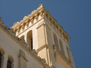 A beige tower rises into the clear blue sky, the weather is sunny, Tunis in Africa with ruins from