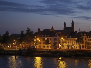 Historic city view in evening light with reflecting water and church, Maastricht, Netherlands