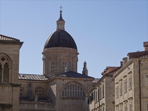 Towering dome against a clear blue sky, surrounded by historic buildings, the old town of Dubrovnik