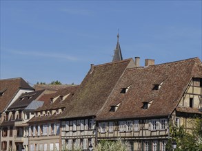 Half-timbered houses with red tiled roofs and historic charm under a clear blue sky, historic house