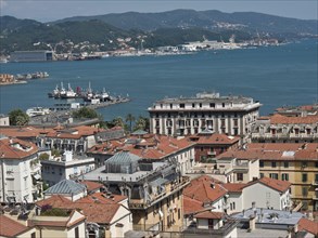 City panorama with red roofs, view of harbour and hills in the distance on a sunny day, Bari,