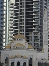 A mosque with golden domes against a backdrop of modern skyscrapers on a sunny day, dubai, arab