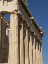 Ancient temple with doric columns under a clear blue sky, ancient columns in front of a blue sky,