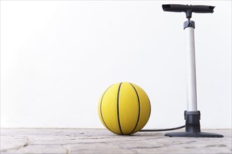 Basketball inflated with a hand pump on a white background