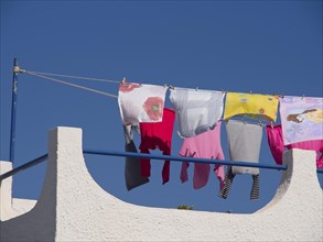 Colourful clothes hanging on a clothesline on a roof under the blue sky, The volcanic island of