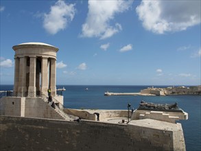 Substantial ancient structure with open columns overlooking the blue sea and clear sky, Valetta,